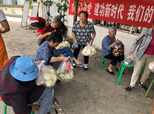 统战部和社区干部及志愿者一起包包子