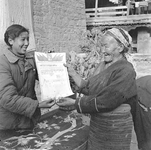1960年拉萨市东城区蔡公堂乡摆脱了奴隶枷锁的老妈妈，以无比兴奋的心情接受土地证。
