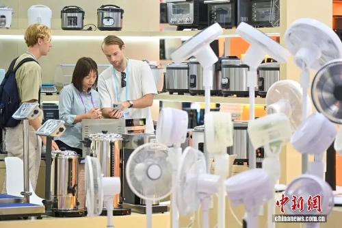 图为第139届中国进出口商品交易会上，境外采购商与家电参展商（中）洽谈