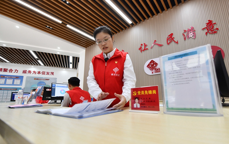 在广西南宁市蟠龙社区，工作人员在为居民服务（2023年12月14日摄）。