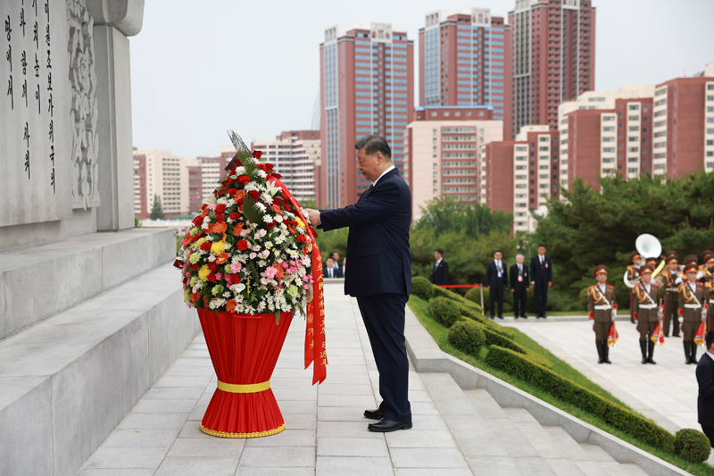 当地时间6月9日上午，正在朝鲜进行国事访问的中共中央总书记、国家主席习近平和夫人彭丽媛参谒中朝友谊塔。朝鲜劳动党总书记、国务委员长金正恩和夫人李雪主陪同。这是习近平整理花篮缎带。
