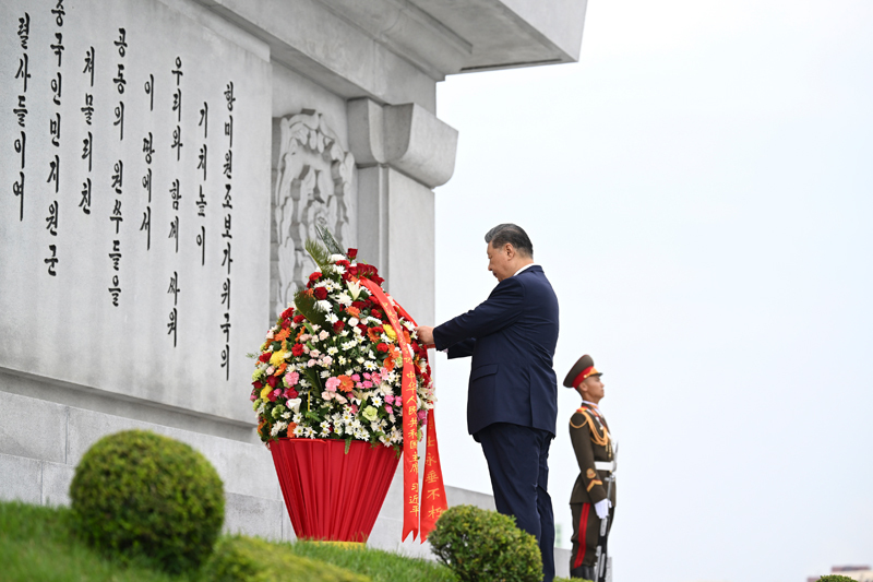 当地时间6月9日上午，正在朝鲜进行国事访问的中共中央总书记、国家主席习近平和夫人彭丽媛参谒中朝友谊塔。朝鲜劳动党总书记、国务委员长金正恩和夫人李雪主陪同。这是习近平整理花篮缎带.
